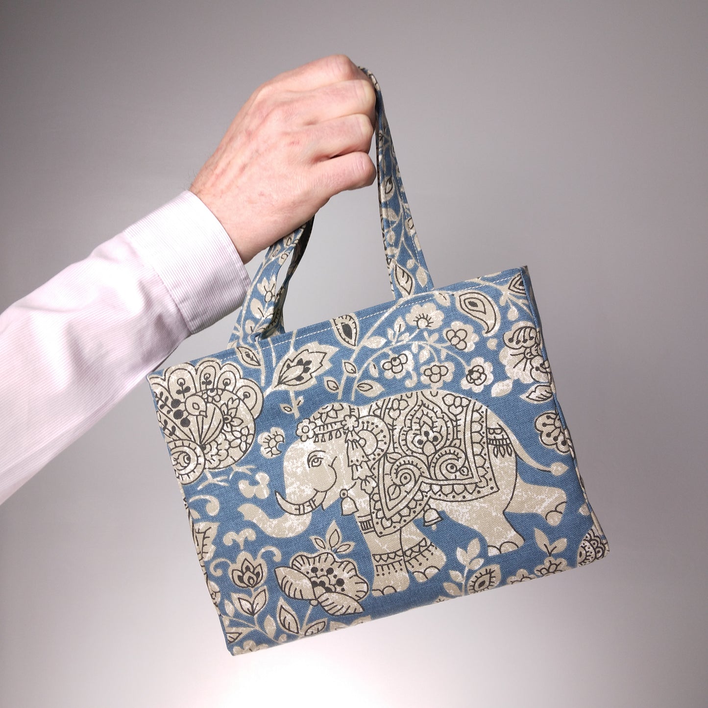 Mini tote bag with ornate taupe elephant design on blue background
