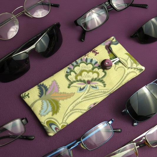 Soft padded eyeglass pouch on a purple background with multiple styles of eyeglasses