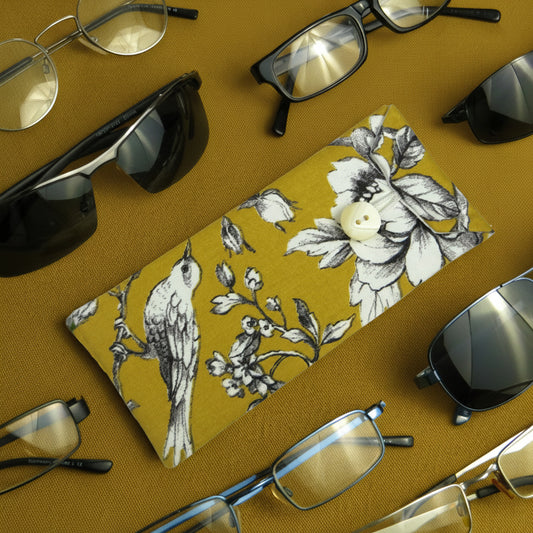 Soft padded eyeglass pouch on a yellow background with multiple styles of eyeglasses