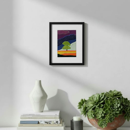 Framed fabric art with a single tree and mountain image
