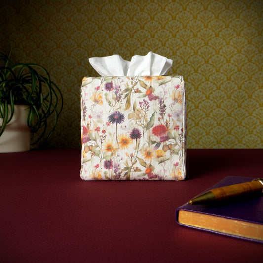 Linen square tissue box cover with a pen, notebook, and plant