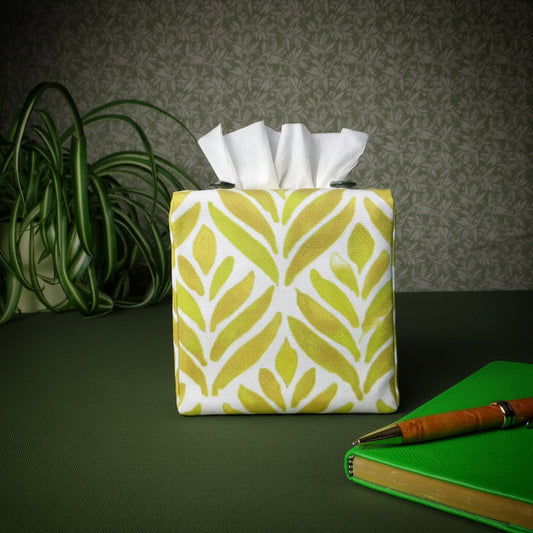 Square tissue box cover with pen, notebook, and plant