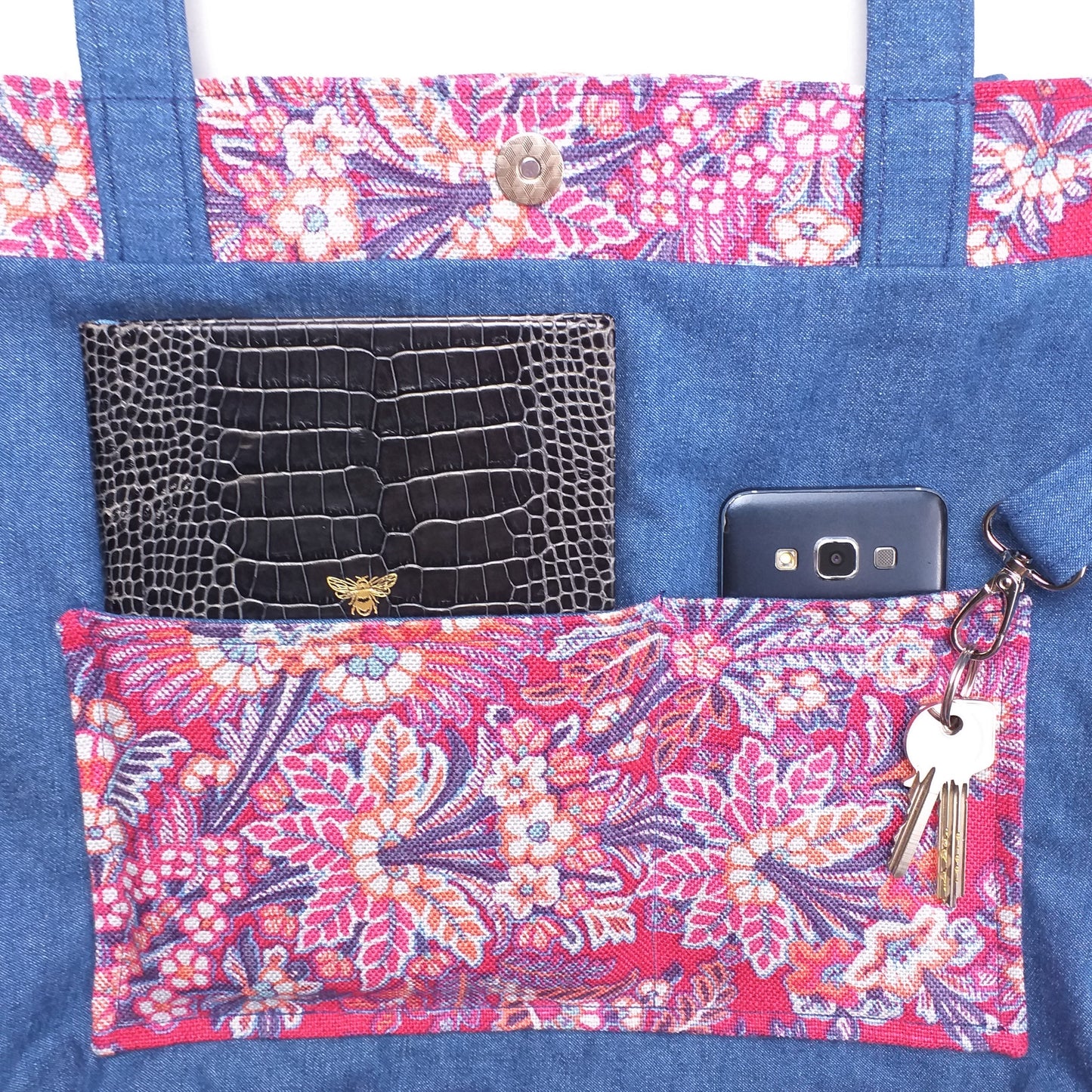 Close up view of a large tote bag interior slip pocket and key clasp