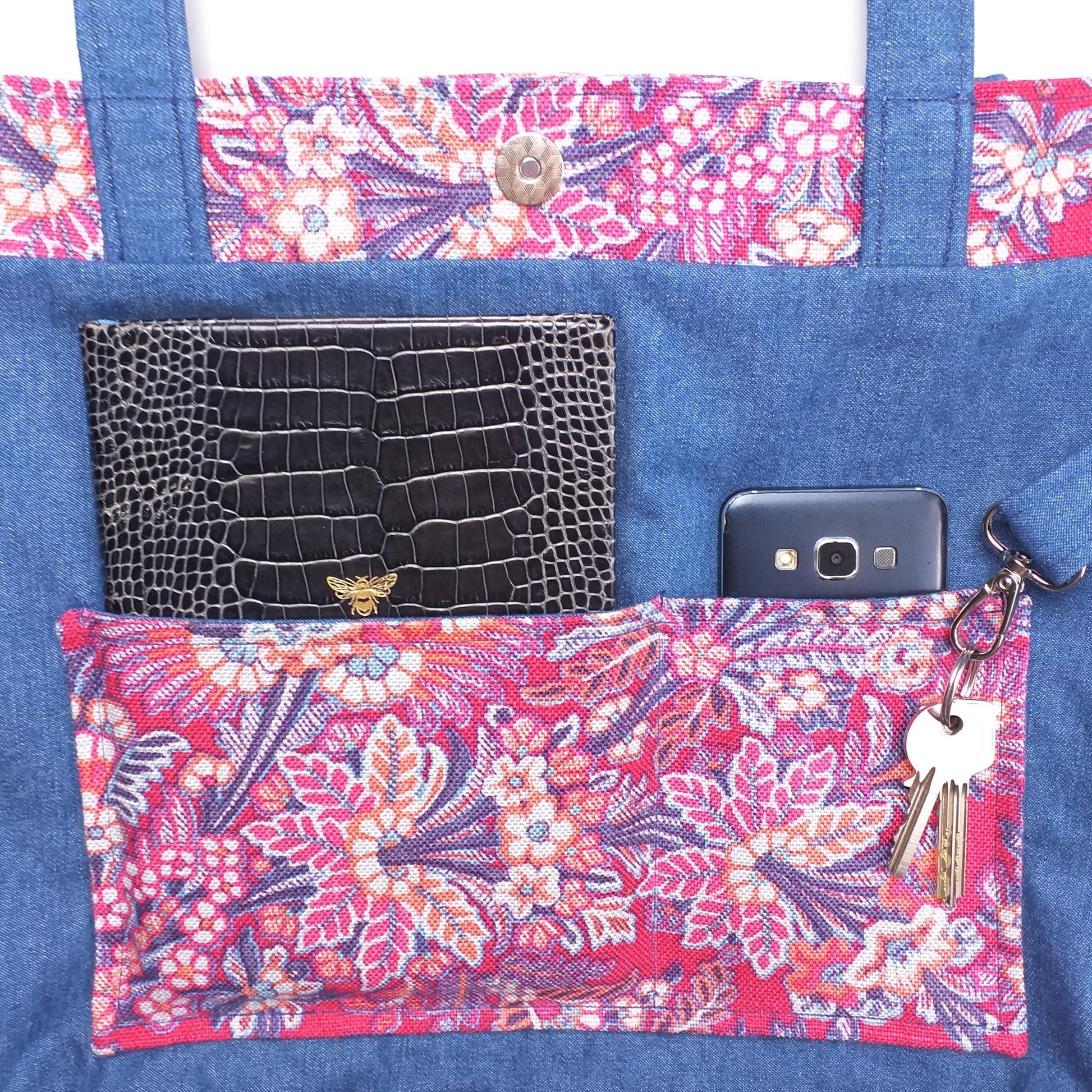 Close up view of a large tote bag interior slip pocket and key clasp