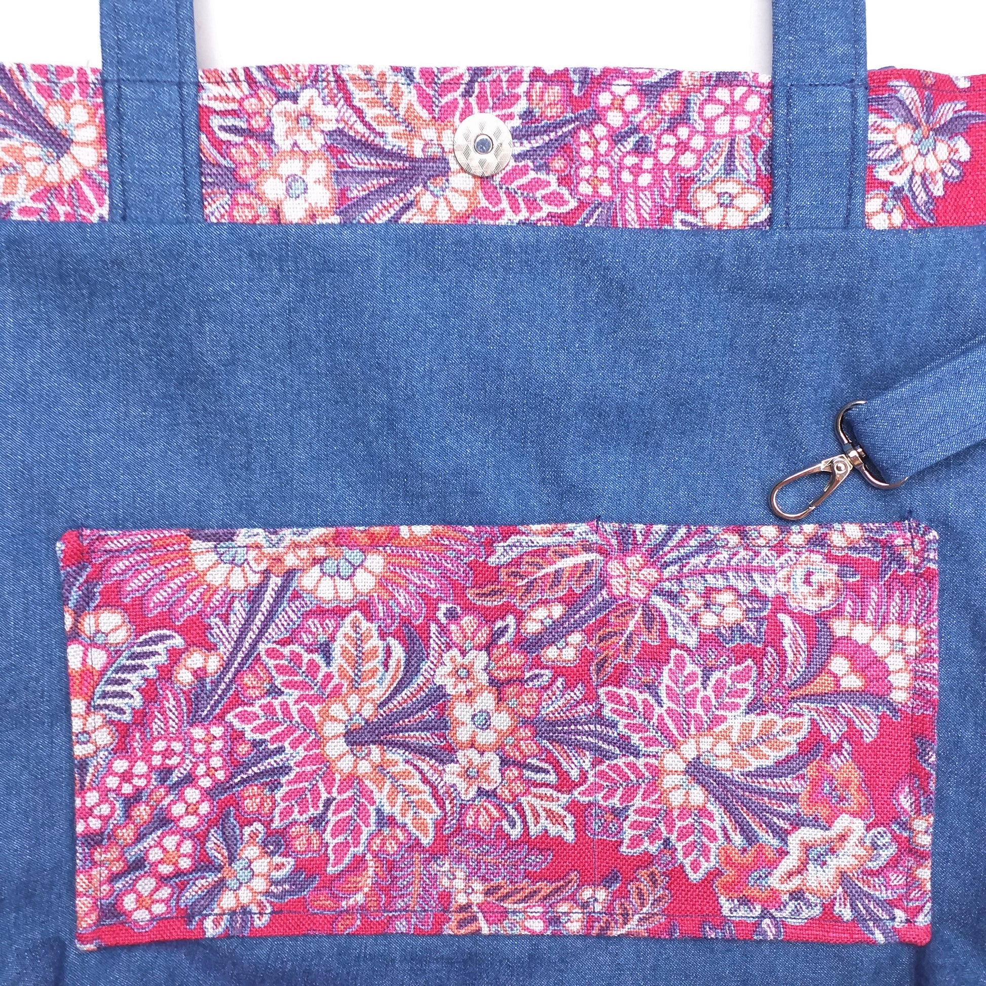 Close up view of a large tote bag interior slip pocket and key clasp