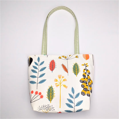 Back view of a large tote bag with multi-colour wild flowers design on off-white background