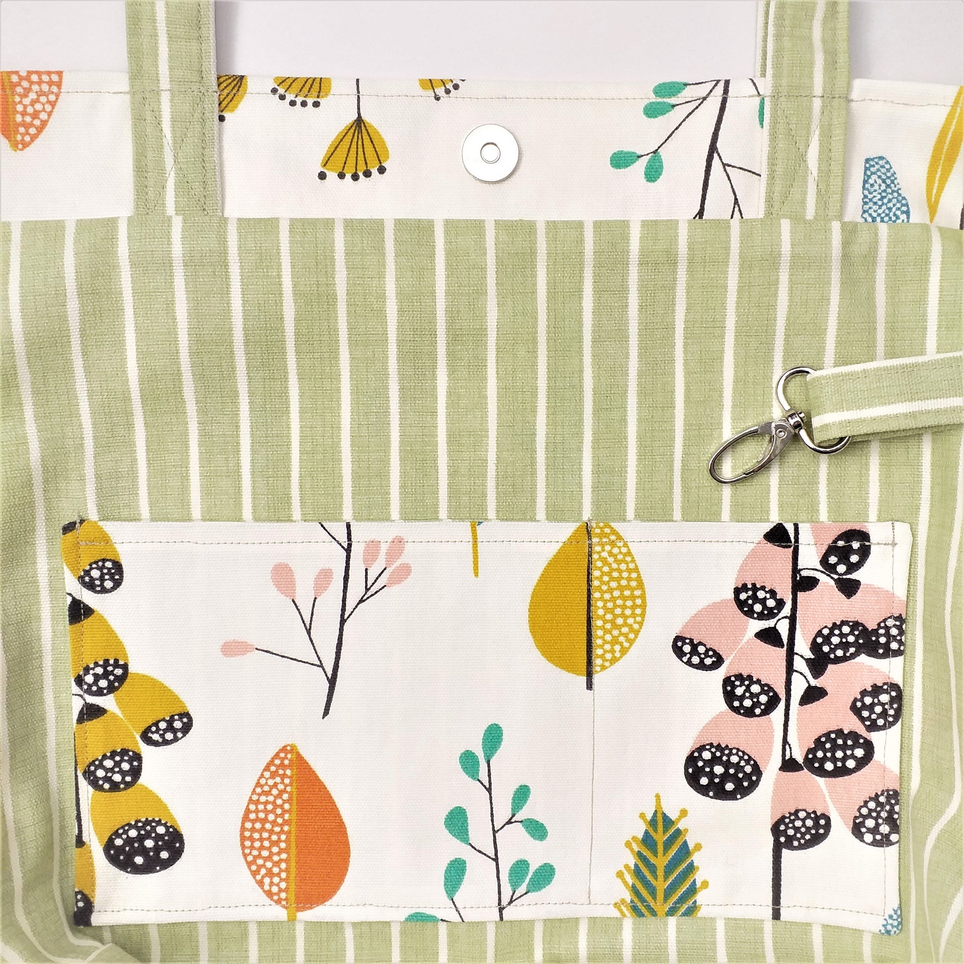 Close up view of a large tote bag interior slip pocket and key clasp