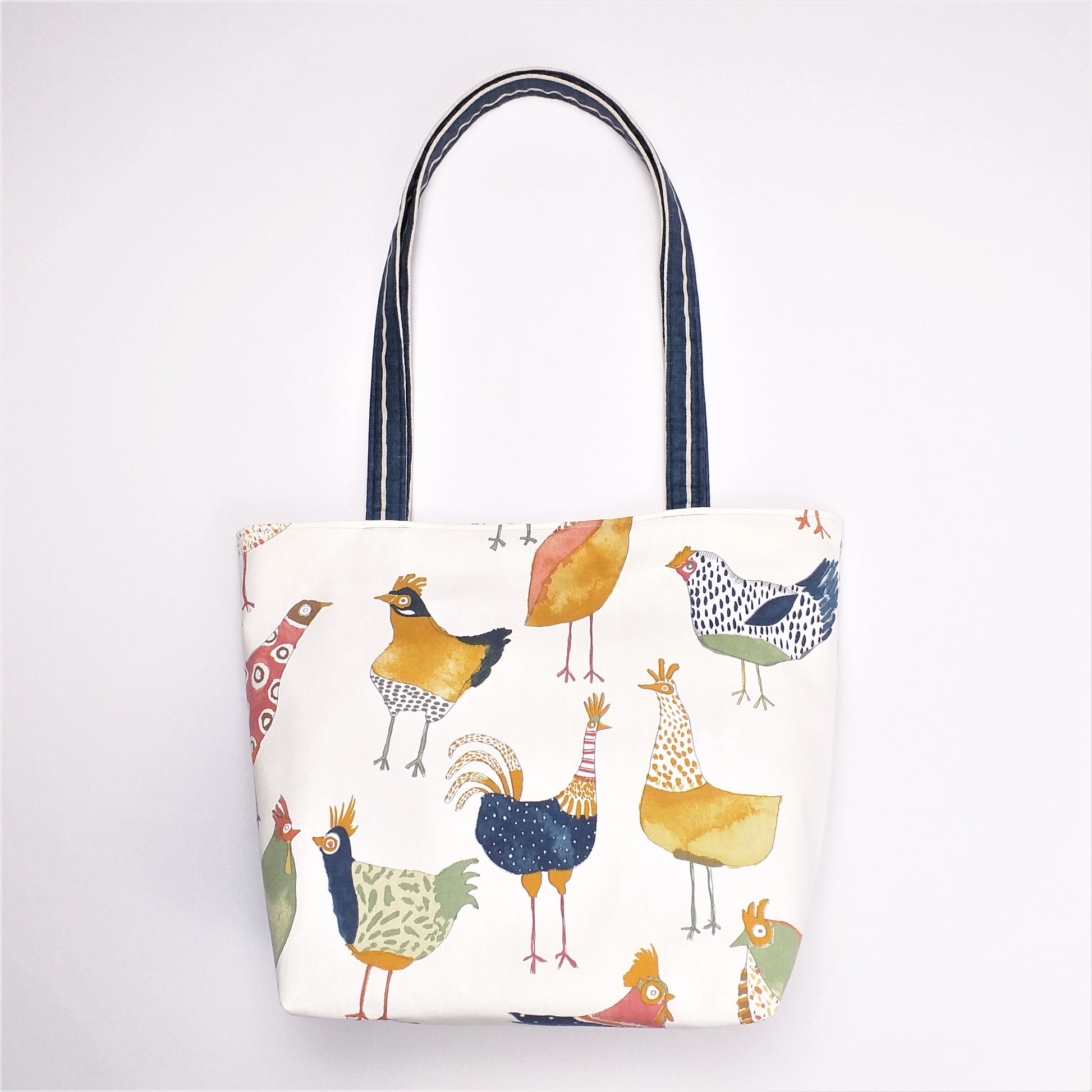 Front view of a large tote bag with multi-colour hens design on beige background
