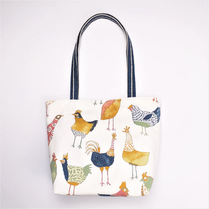 Front view of a large tote bag with multi-colour hens design on beige background