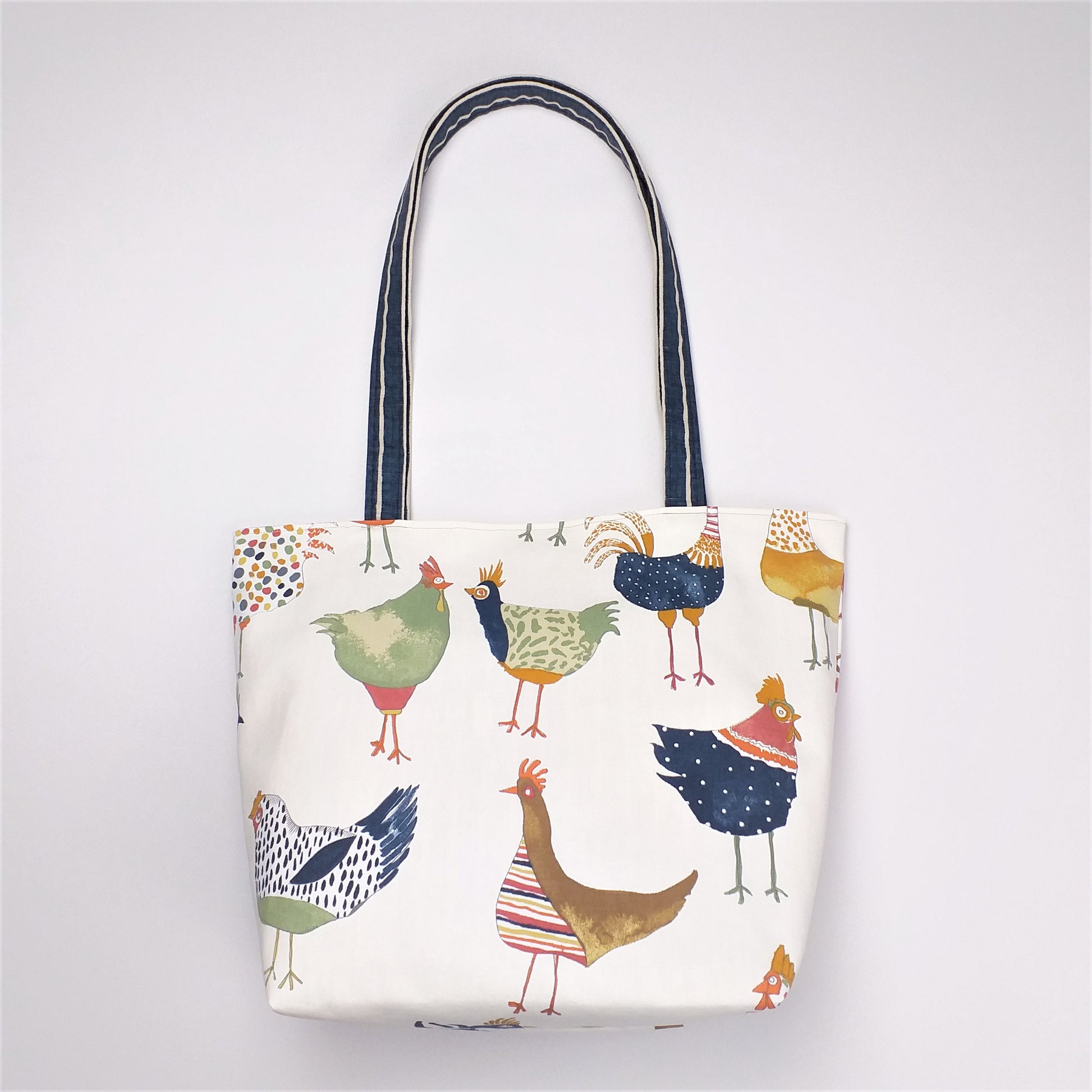 Back view of a large tote bag with multi-colour hens design on beige background