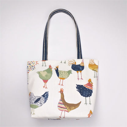 Back view of a large tote bag with multi-colour hens design on beige background