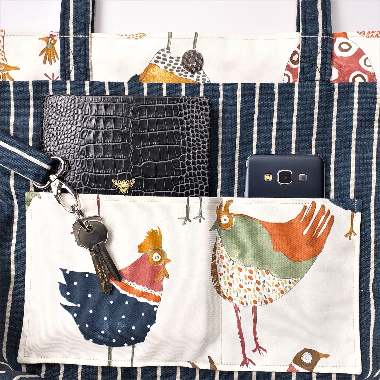 Close up view of a large tote bag interior slip pocket and key clasp