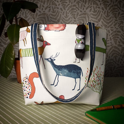 Large handmade tote bag with multi-colour deer, foxes, squirrels, rabbits, and hedgehogs design on off-white background
