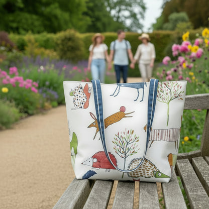 Handmade cotton large tote bag with shoulder straps and an animal design sitting on a park bench