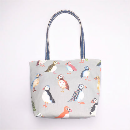 Front view of a large tote bag with multi-colour puffins design on grey background