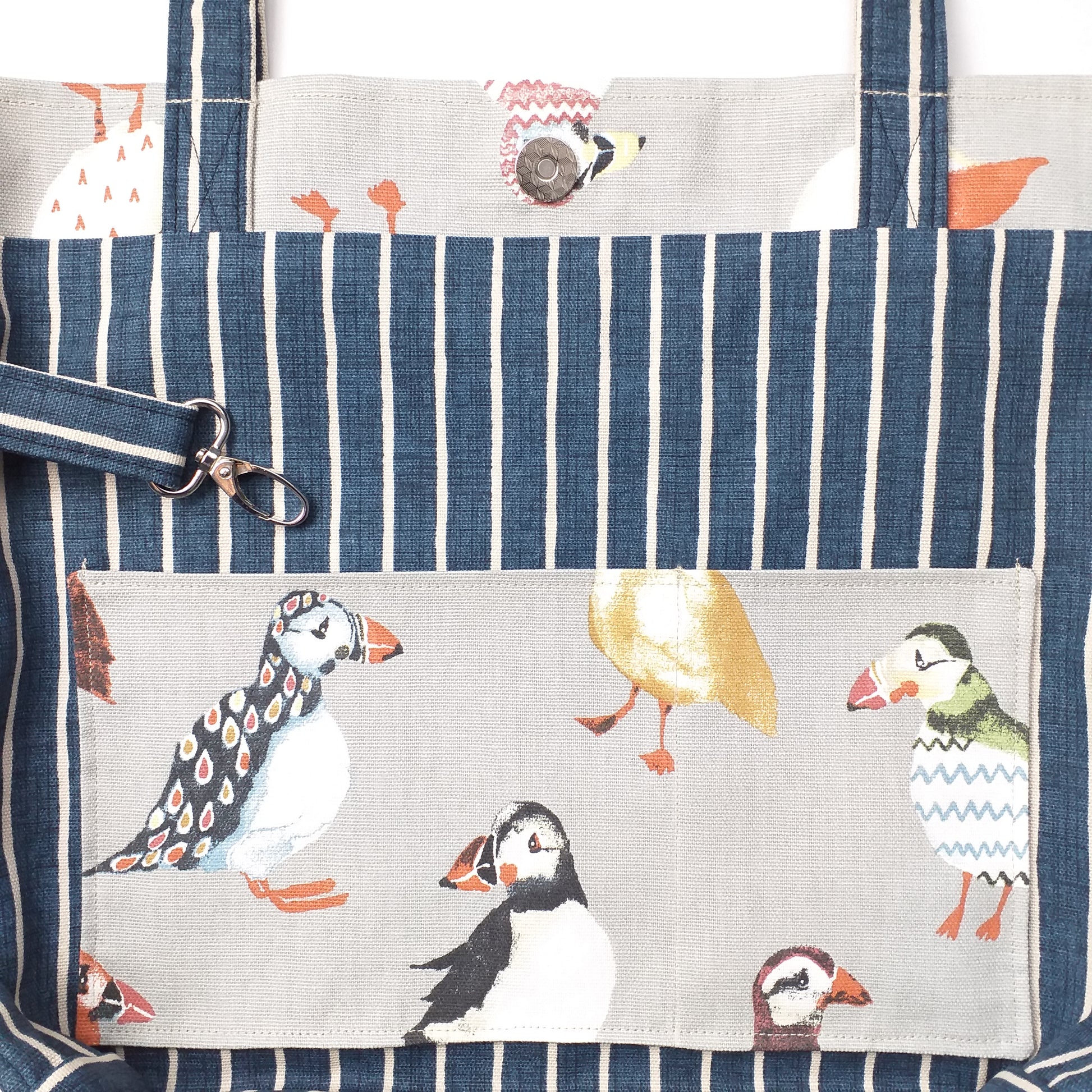 Close up view of a large tote bag interior slip pocket and key clasp