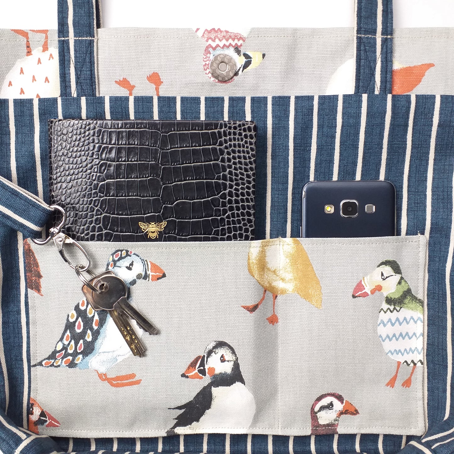 Close up view of a large tote bag interior slip pocket and key clasp