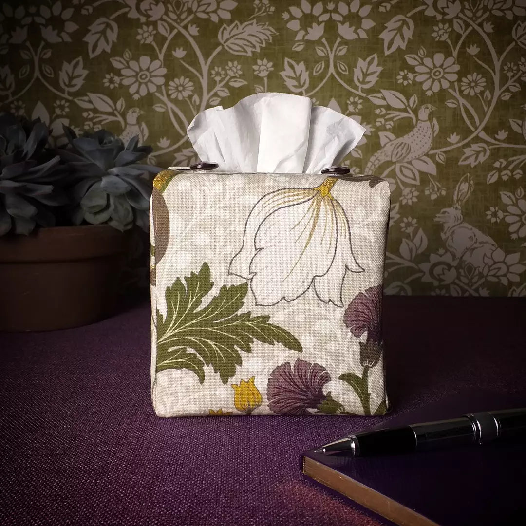 Square tissue box cover with a pen, notebook, and plant