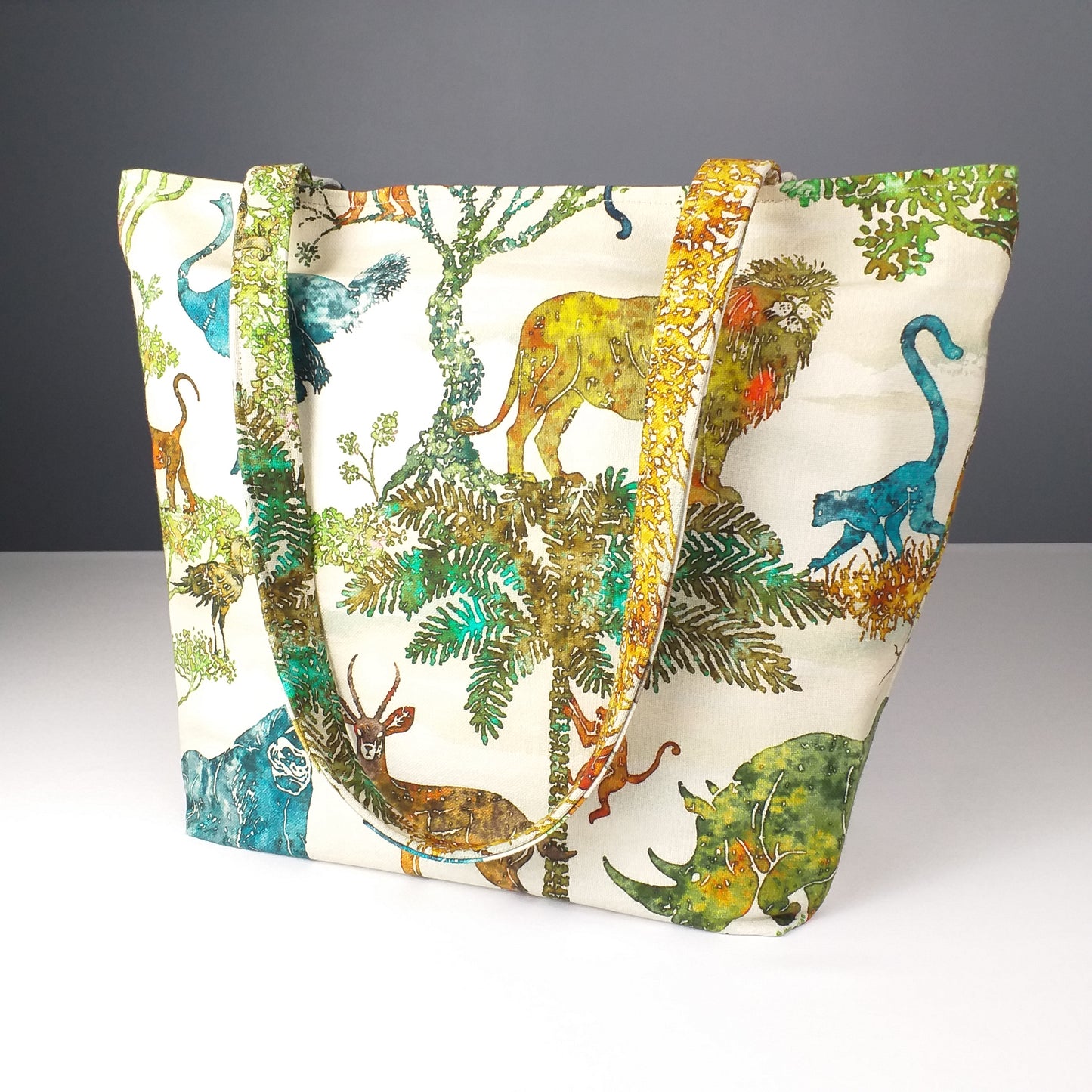 Side view of a large cotton tote bag with elephant, giraffe, water buffalo, monkey, panther, gorilla, lemur, rhinoceros design