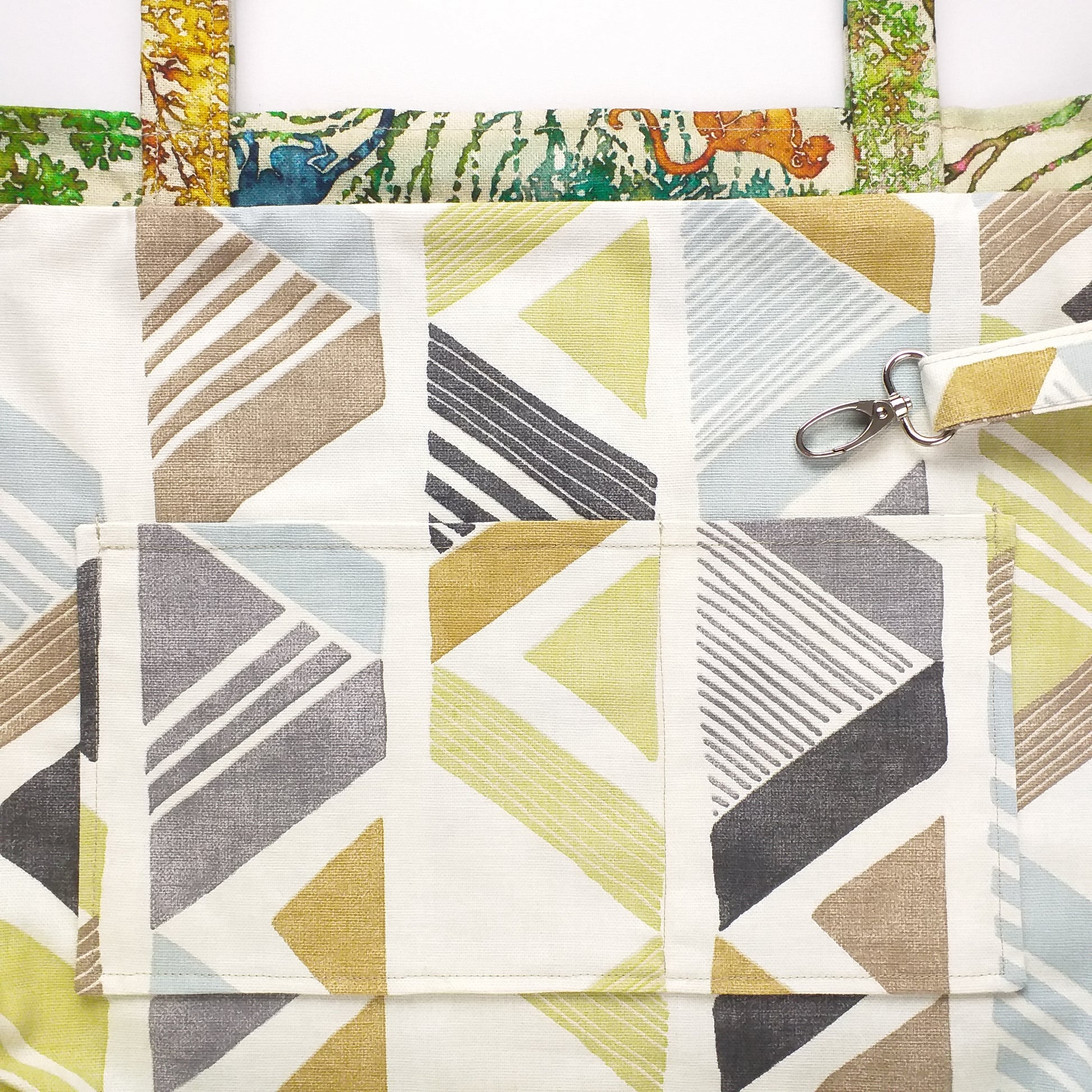 Close up view of a large tote bag interior slip pocket and key clasp