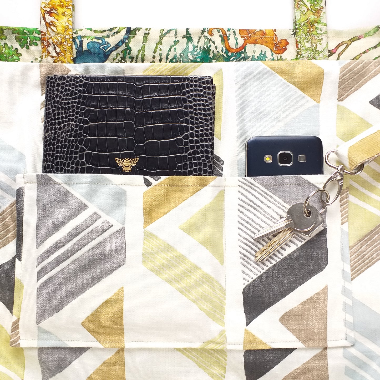 Close up view of a large tote bag interior slip pocket and key clasp
