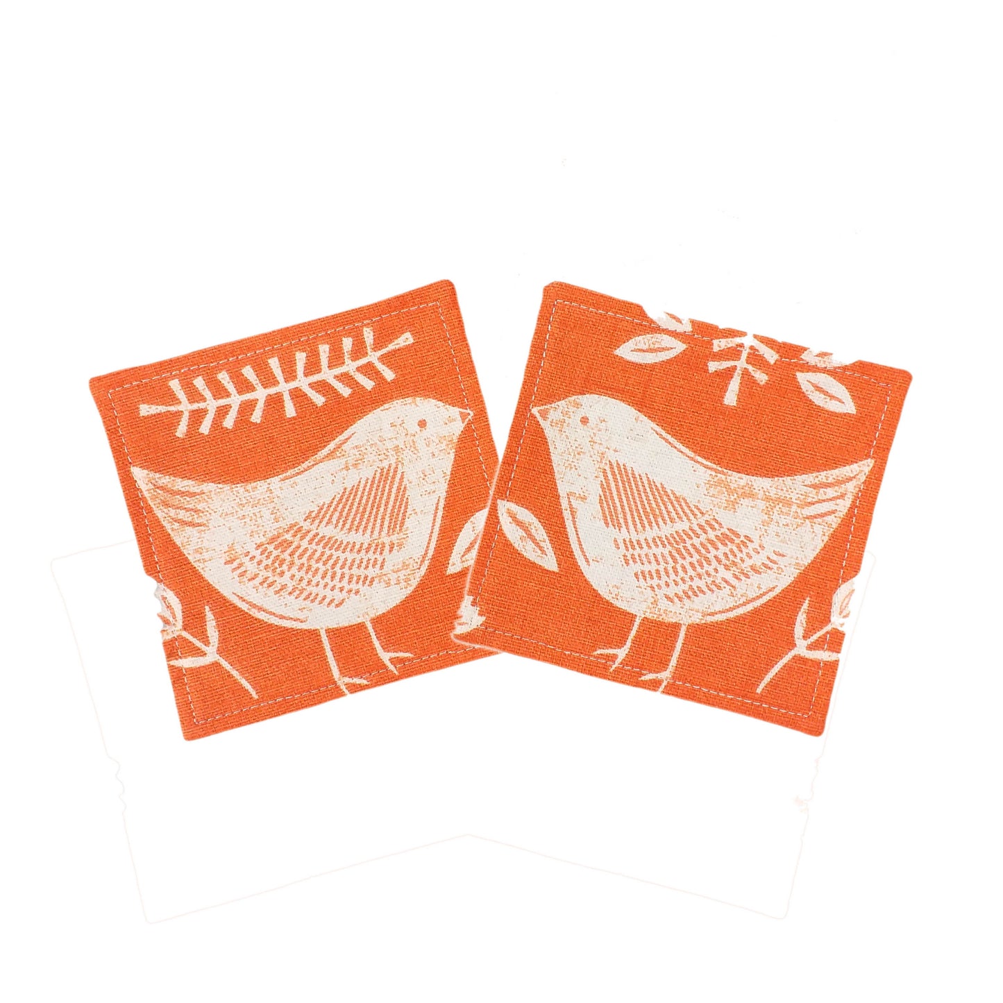 Square coasters with white bird design on orange background