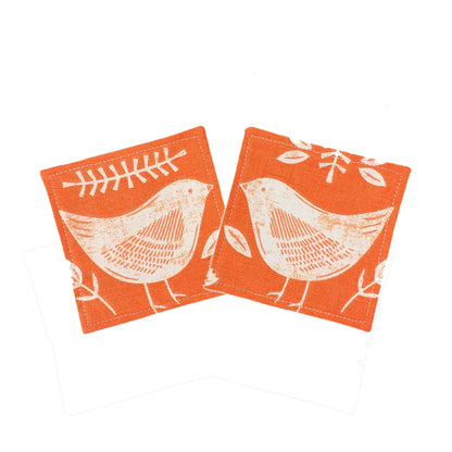 Square coasters with white bird design on orange background