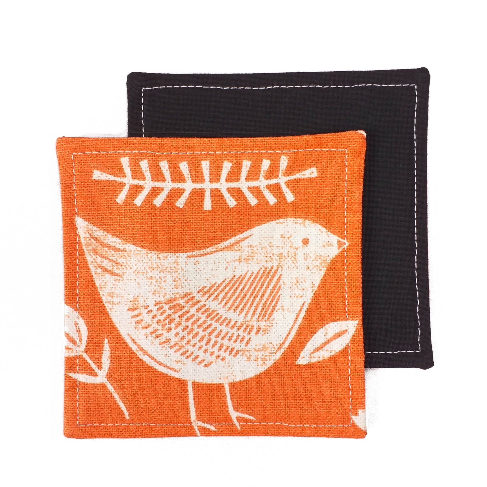 Square coasters with white bird design on orange background