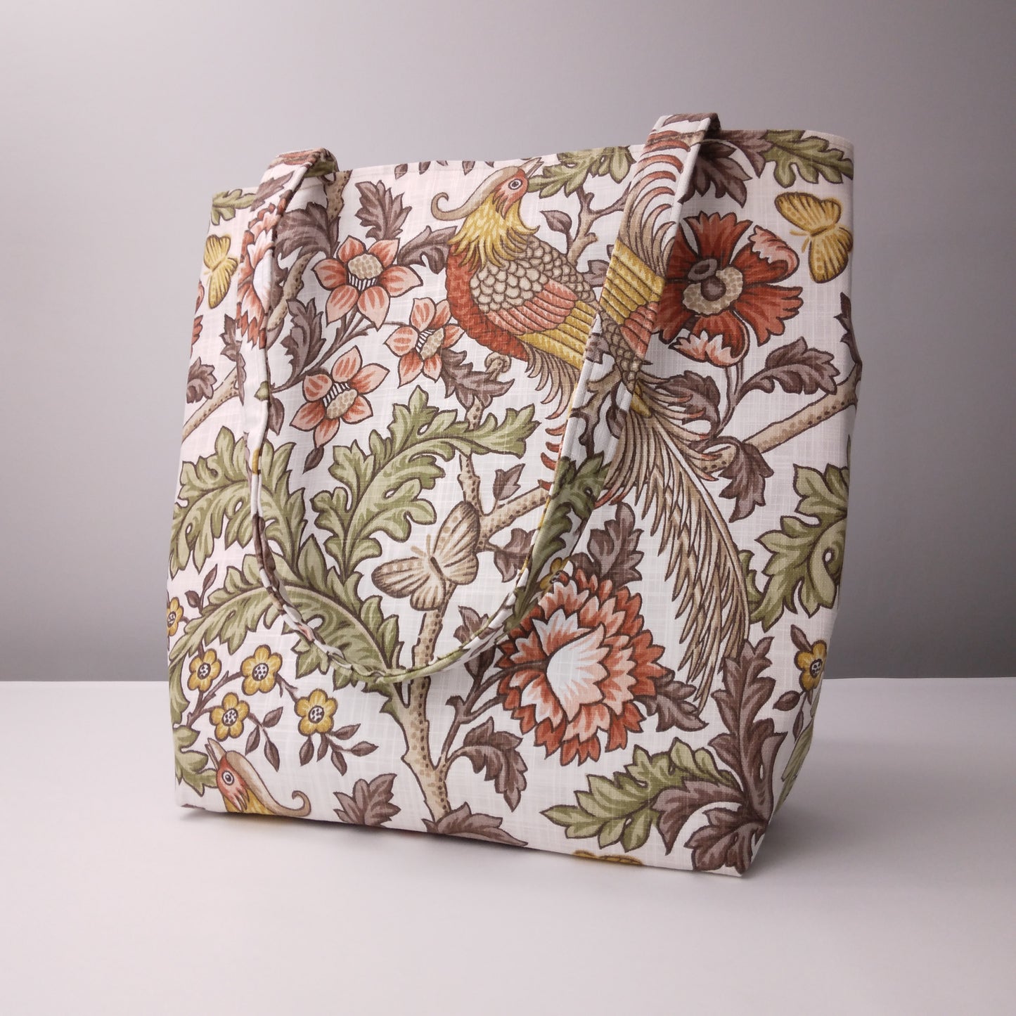Side view of a large tote bag with pheasants and flowers design on natural colour background