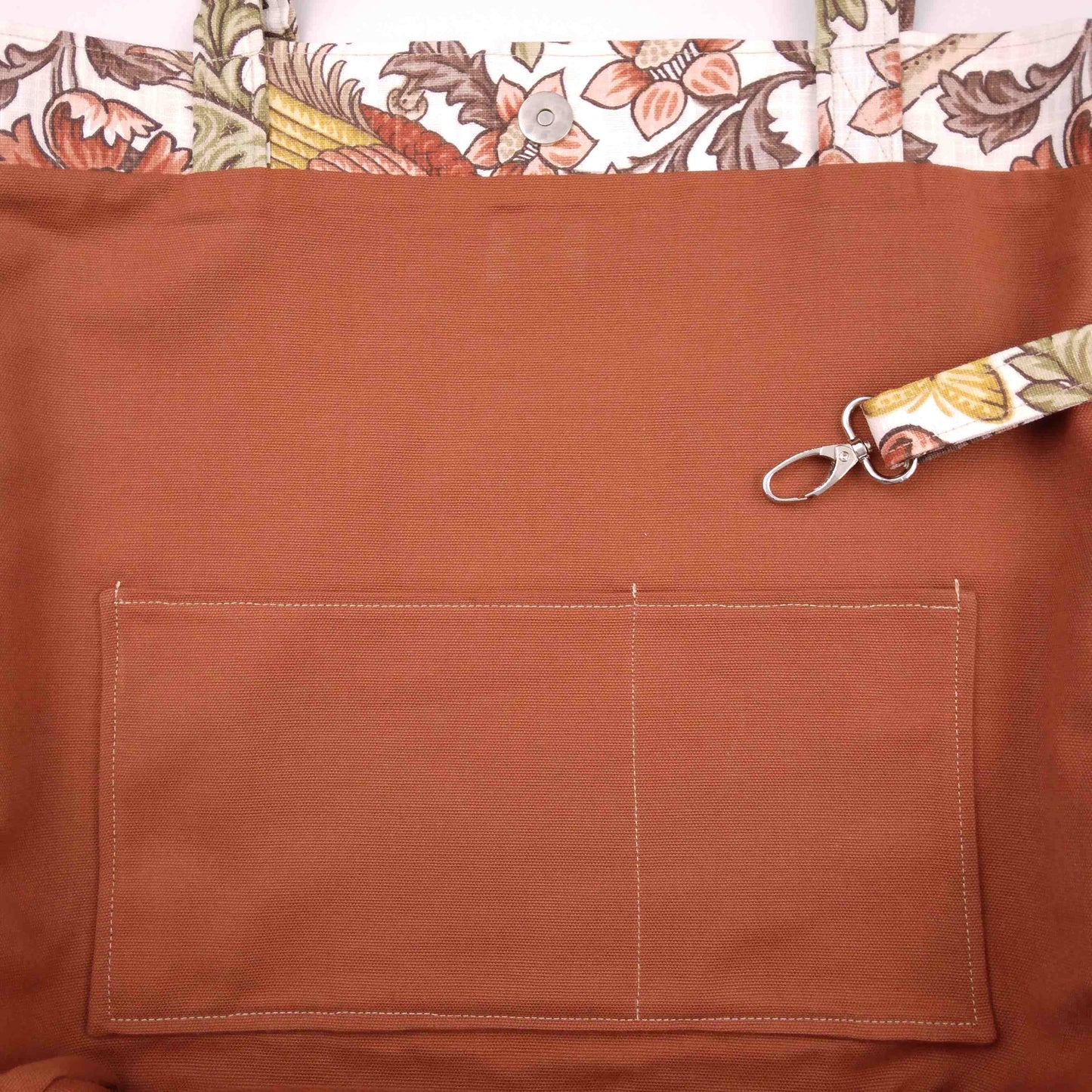 Close up view of a large tote bag interior slip pocket and key clasp