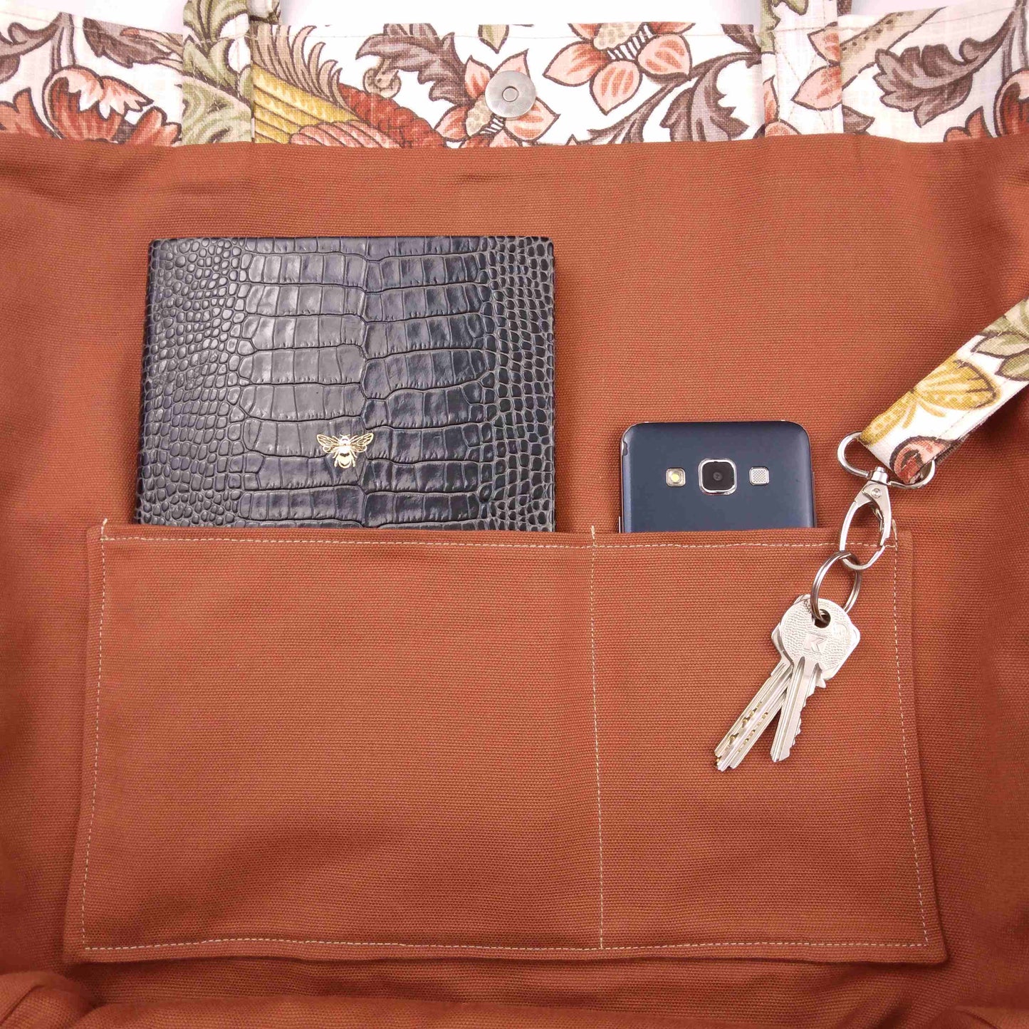 Close up view of a large tote bag interior slip pocket and key clasp