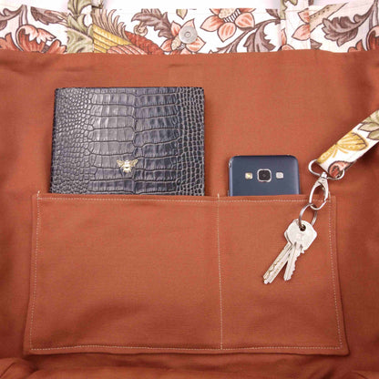 Close up view of a large tote bag interior slip pocket and key clasp