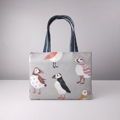 Front view of a mini tote bag with multi-colour puffins design on grey background