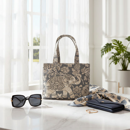 Mini tote bag with ornate taupe elephant design on grey background sitting on a window table in a living room