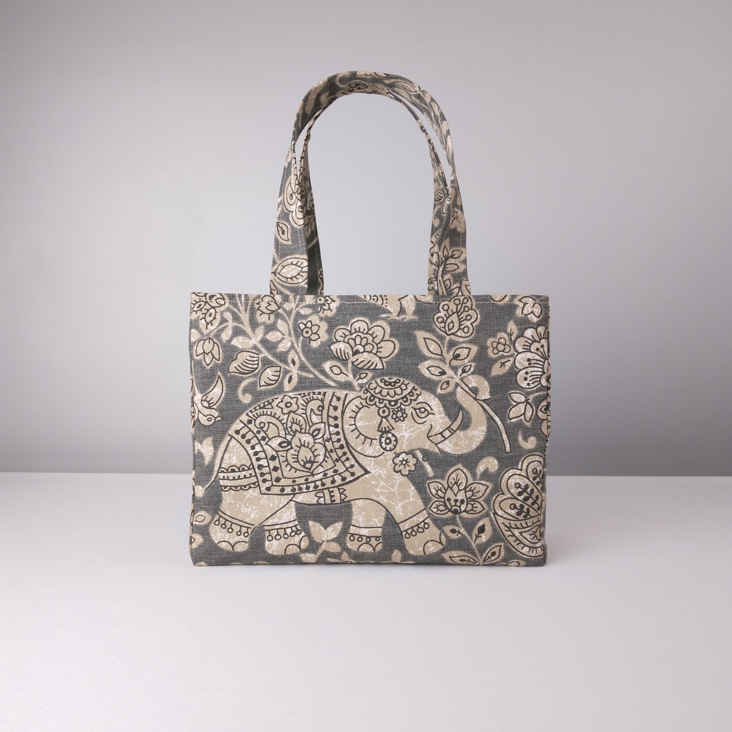 Mini tote bag with ornate taupe elephant design on grey background
