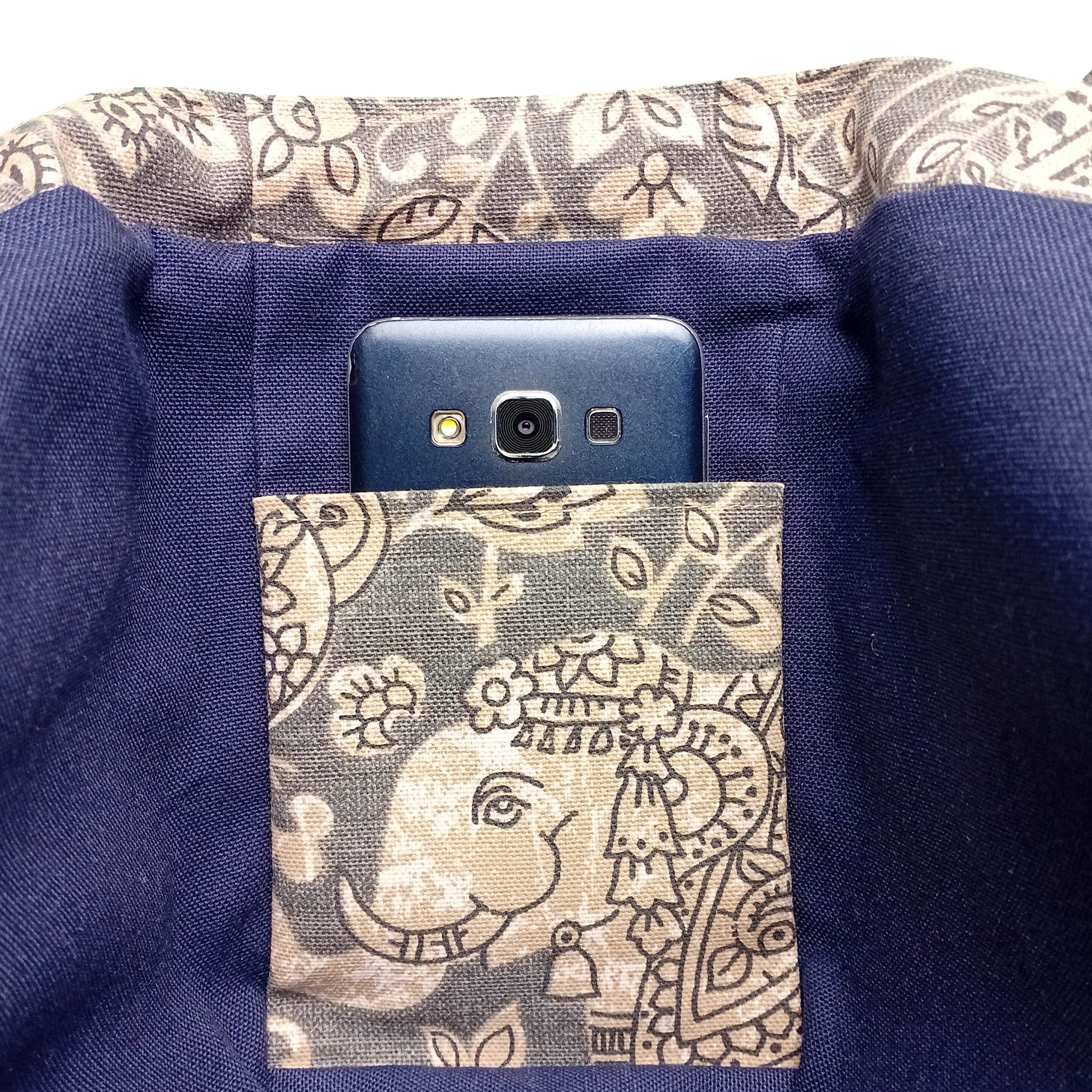 Close up view of an interior slip pocket in a grey elephant design mini tote bag