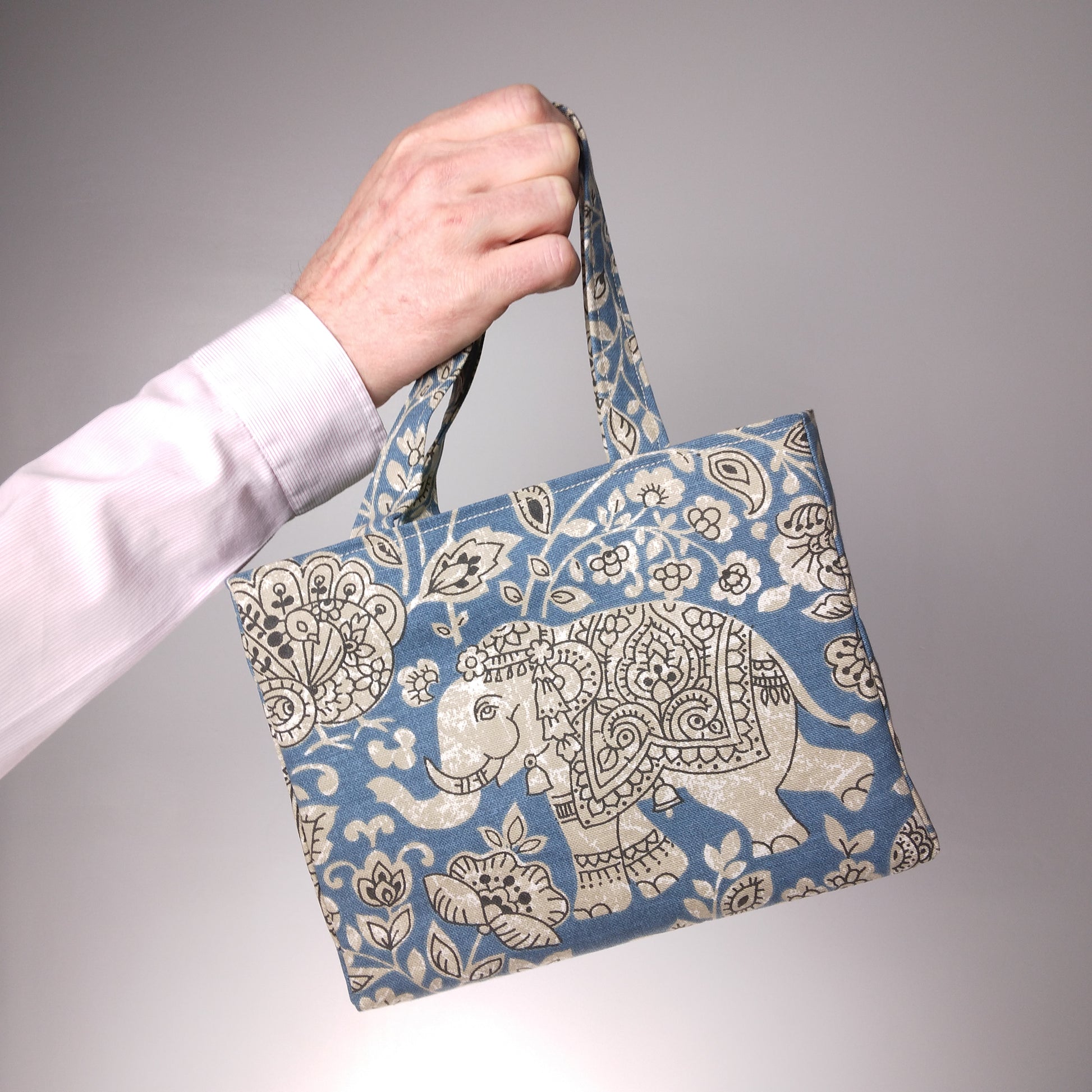 Mini tote bag with ornate taupe elephant design on blue background