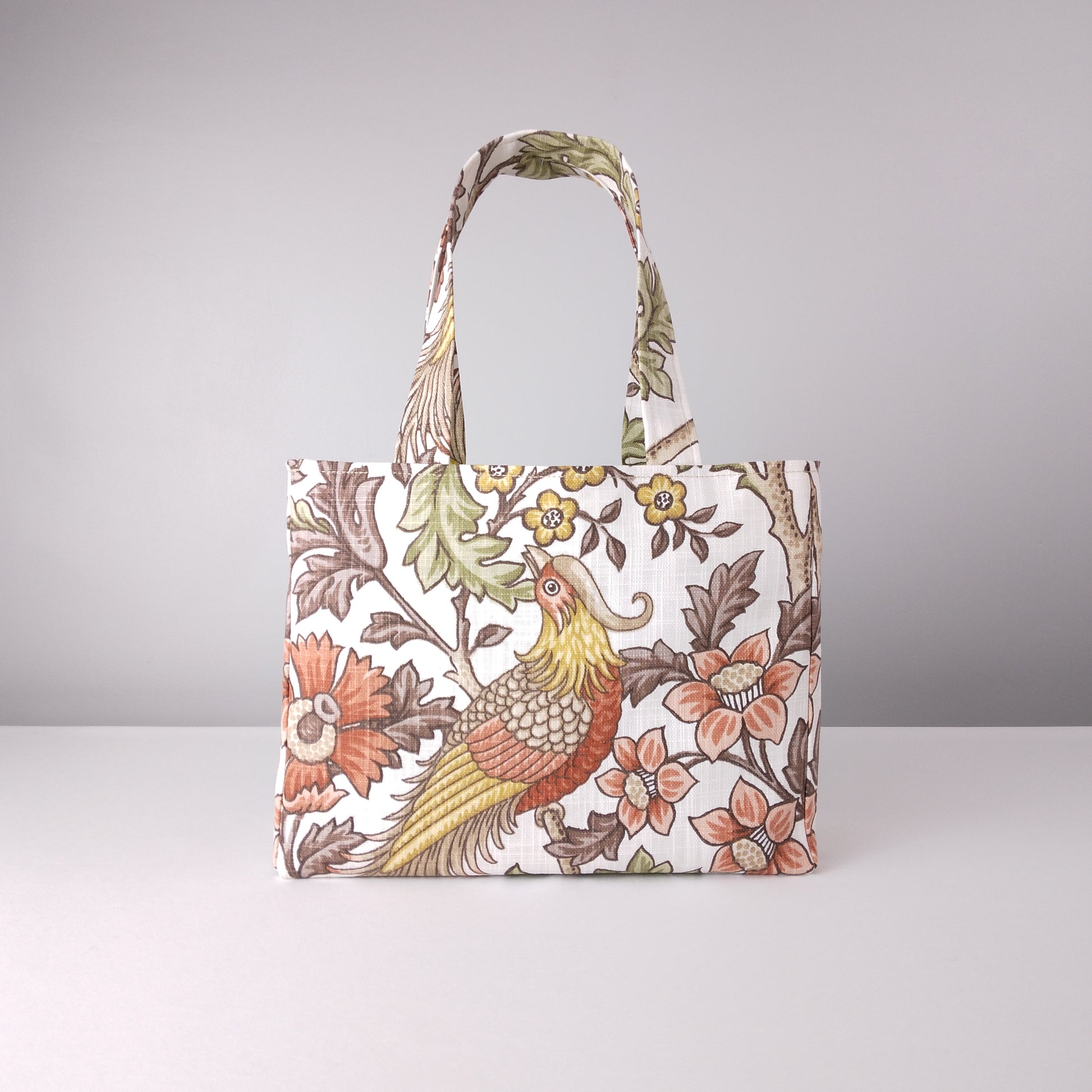 Front view of a mini tote bag with pheasants and flowers design on off-white colour background
