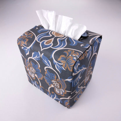 Back view of square tissue box cover with white, brown, and blue baroque style floral design on navy background