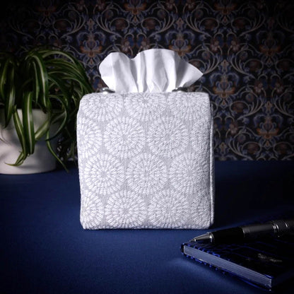 Square tissue box cover with a pen, notebook, and plant