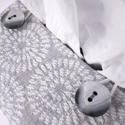 Close up view of square tissue box cover with buttons