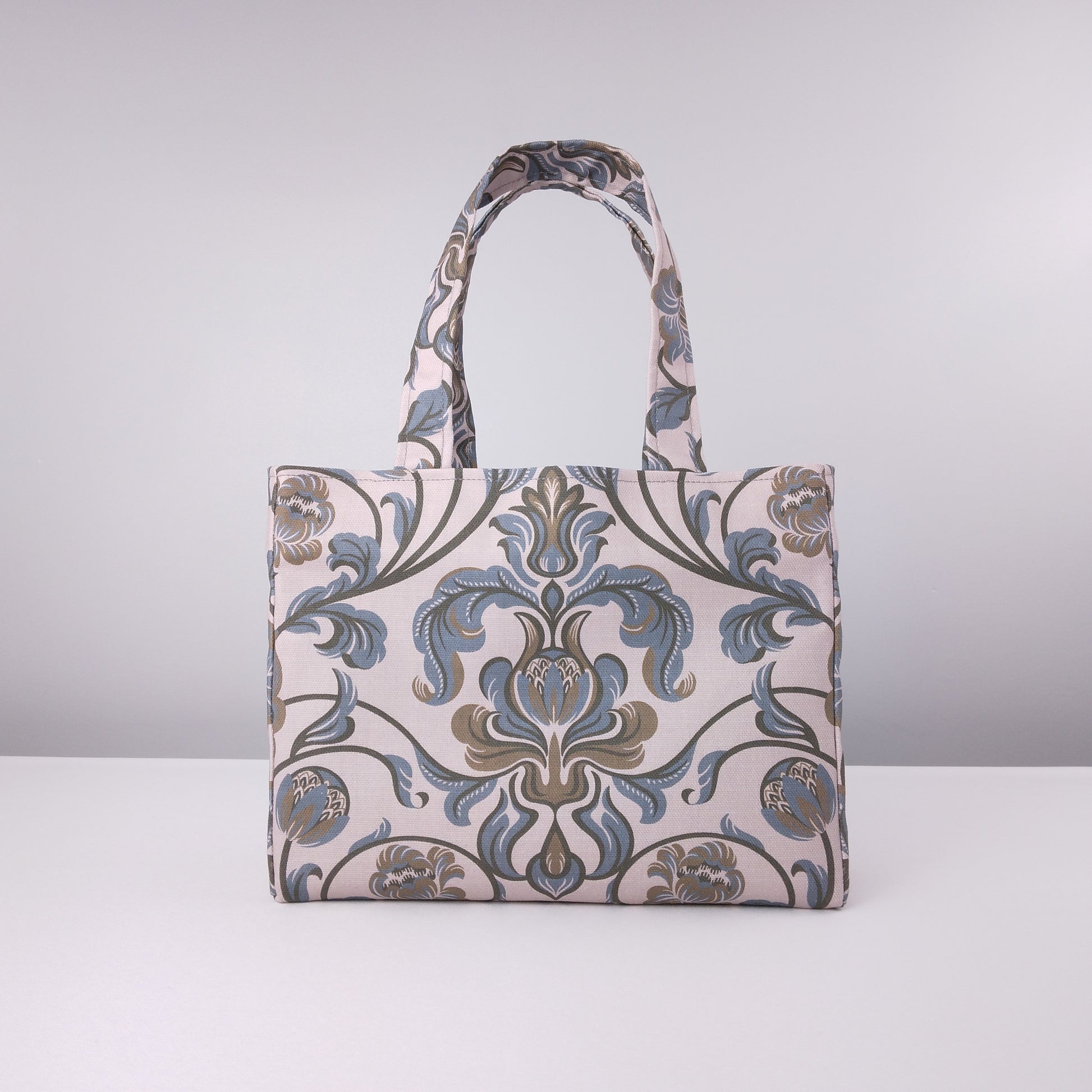 Mini tote bag with grey and brown baroque style floral design on taupe background