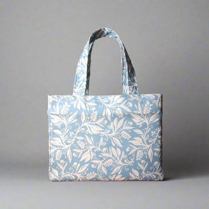 Mini tote bag with white wildflower silhouette design on light blue background