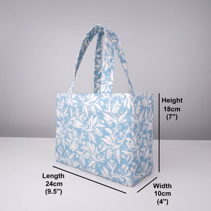 Mini tote bag with white wildflower silhouette design on light blue background