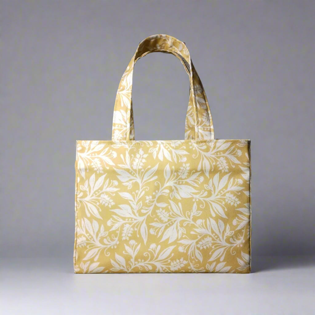 Mini tote bag with white wildflower silhouette design on yellow background