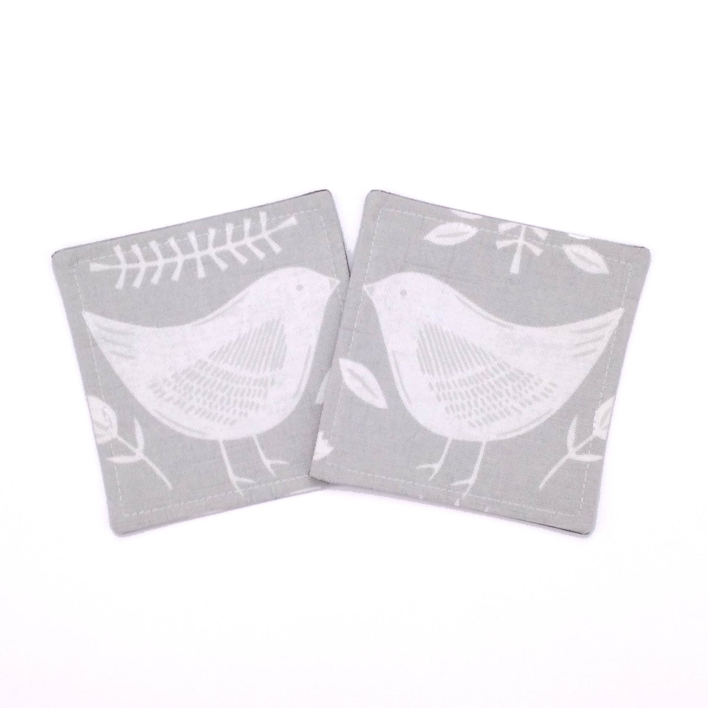 Square coasters with white bird design on grey background
