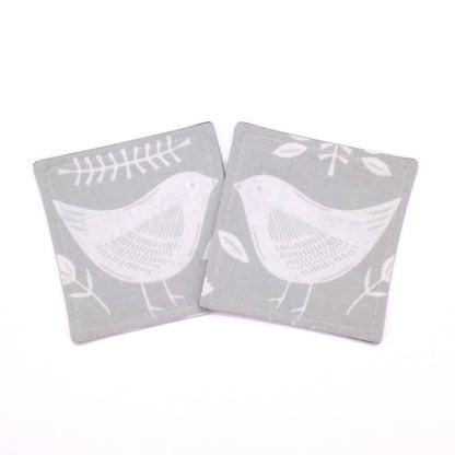 Square coasters with white bird design on grey background