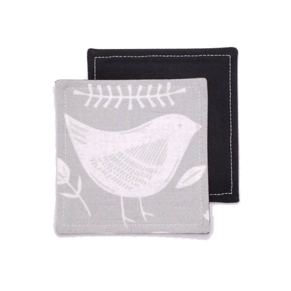 Square coasters with white bird design on grey background