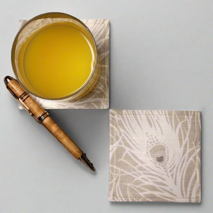 Square coasters with white peacock feathers design on natural colour background