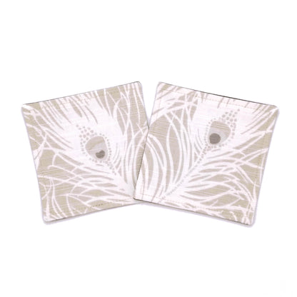 Square coasters with white peacock feathers design on natural colour background